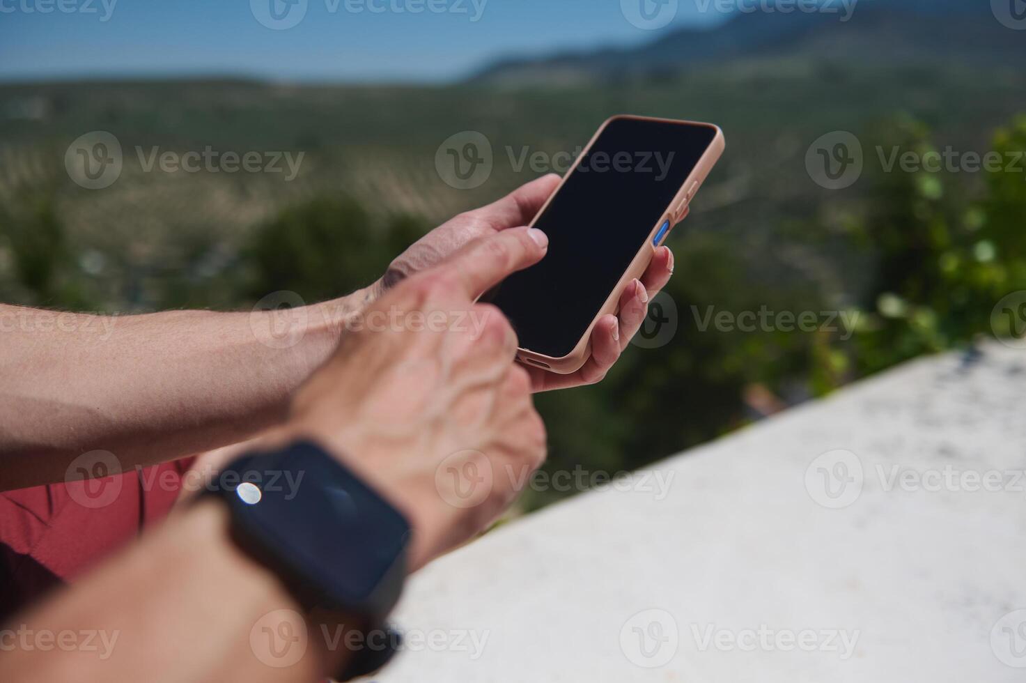 Close-Up of Hands Using a Smartphone Outdoors During a Scenic Adventure photo