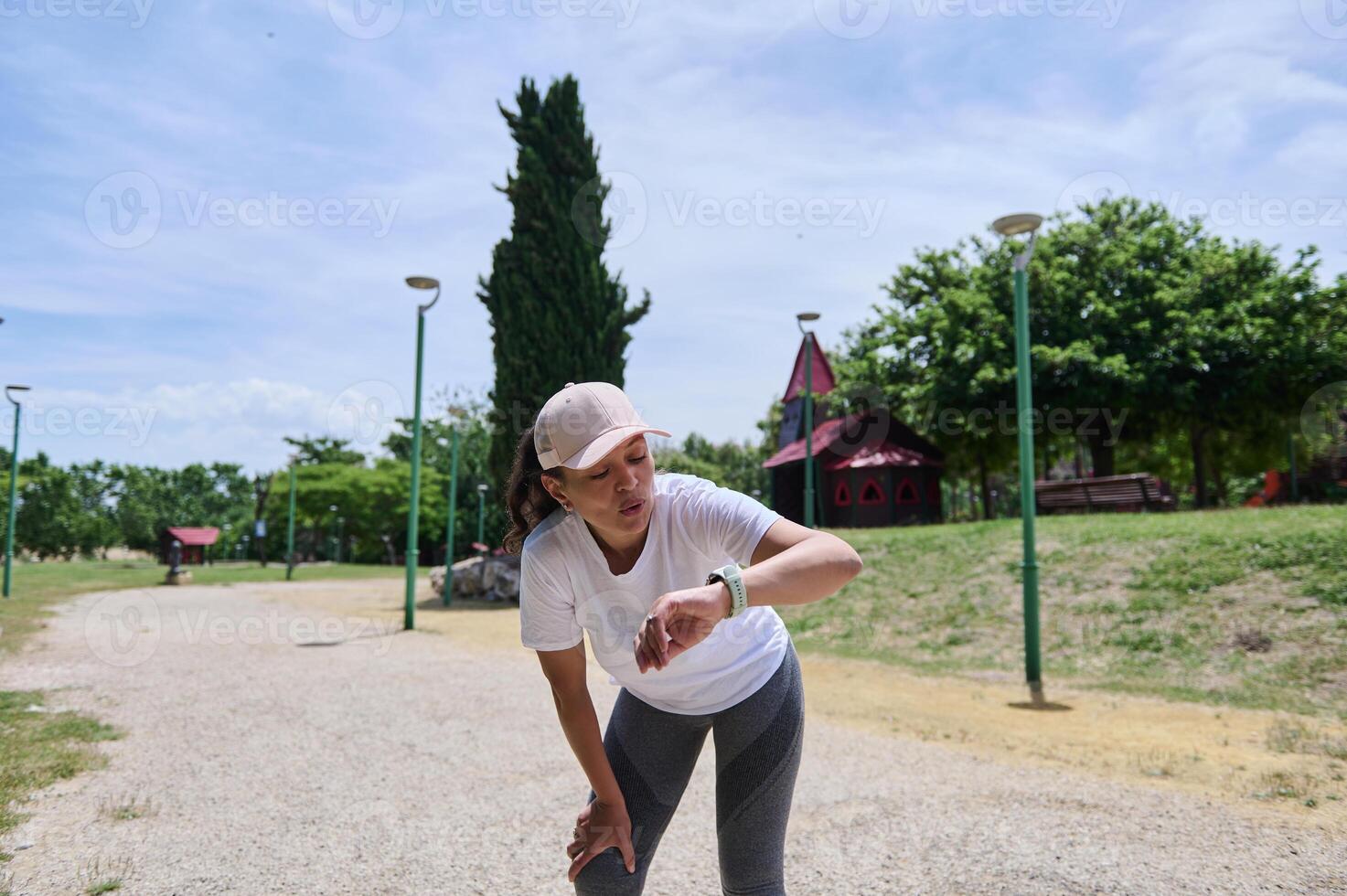 Woman Checking Smartwatch After Outdoor Workout Session in Park photo