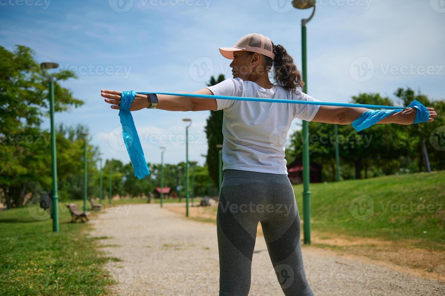 Woman Exercising Outdoors Using Resistance Band in a Park Setting photo