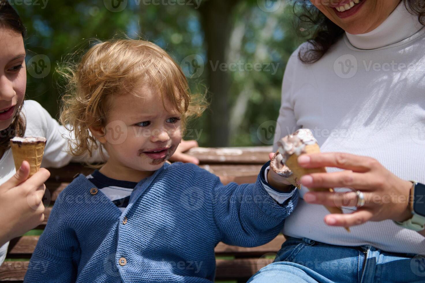 Mother and Children Enjoying Ice Cream Together Outdoors on a Bright Day photo