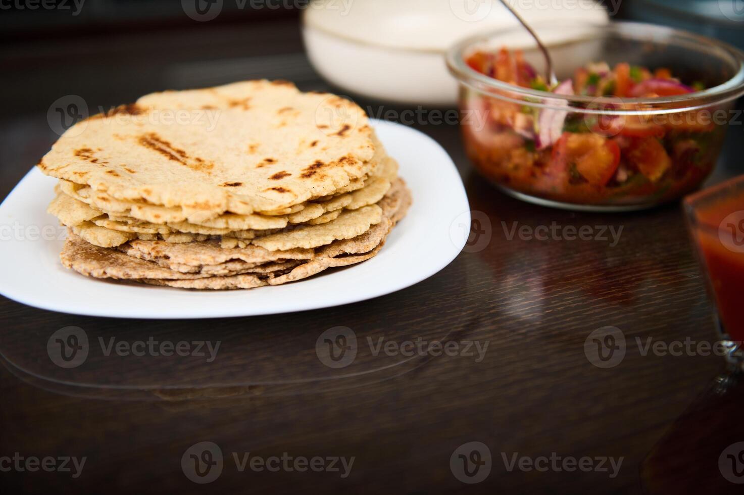 Plate of Freshly Made Tortillas and Salsa Displayed on a Wooden Table photo