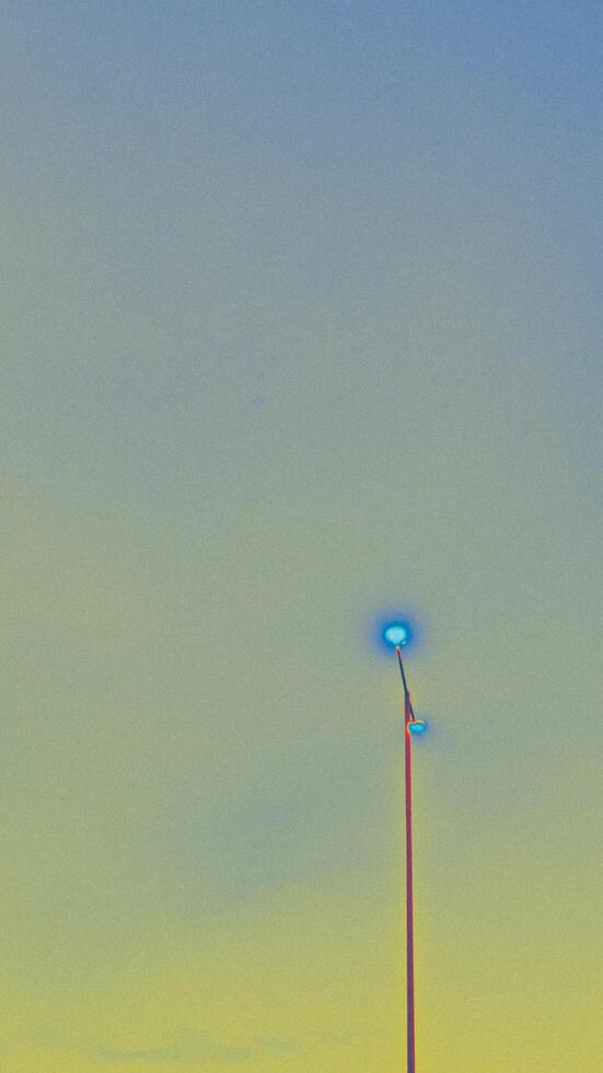 Abstracted Streetlight Against a Graded Sky with Blue and Yellow Hues photo