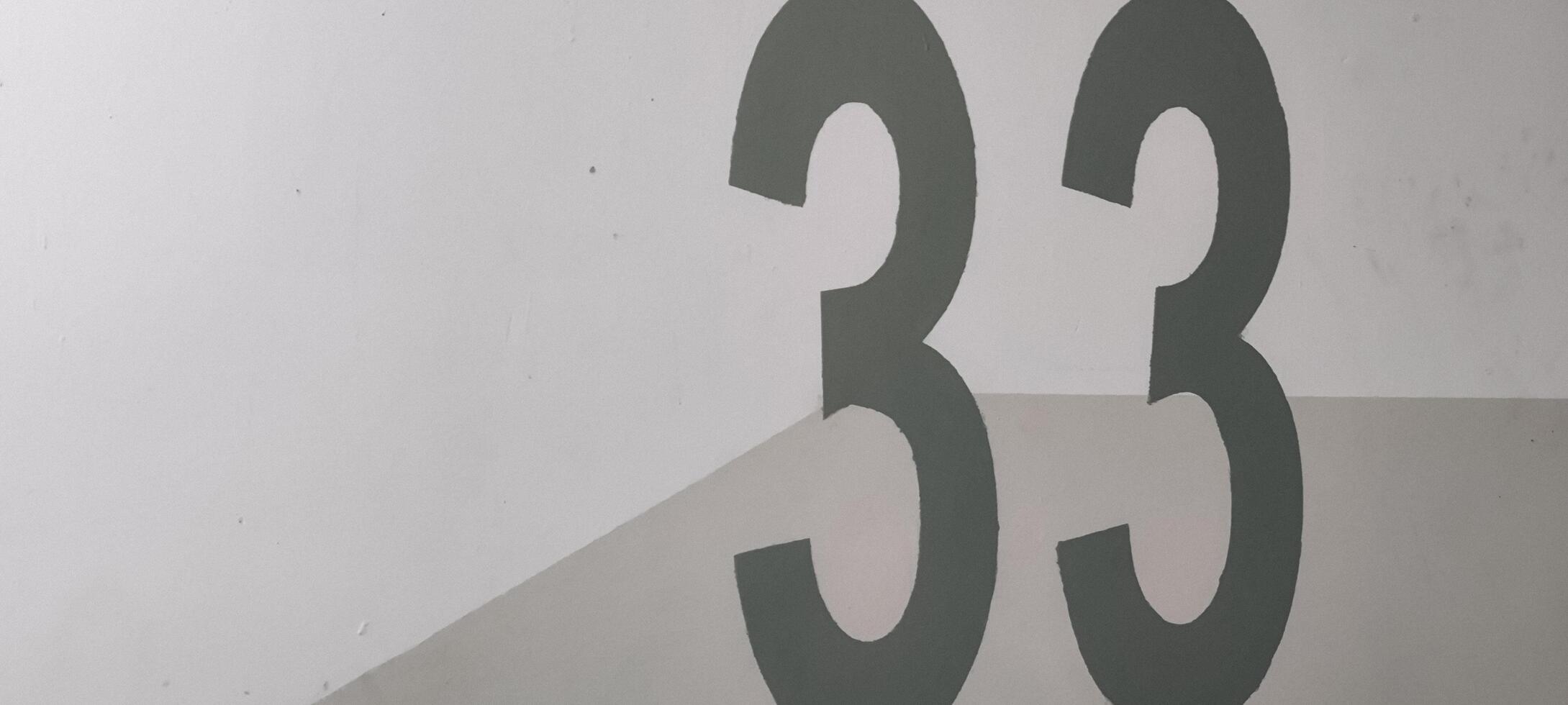 Graphic Composition of Number Thirty-Three on Textured White and Gray Surface photo