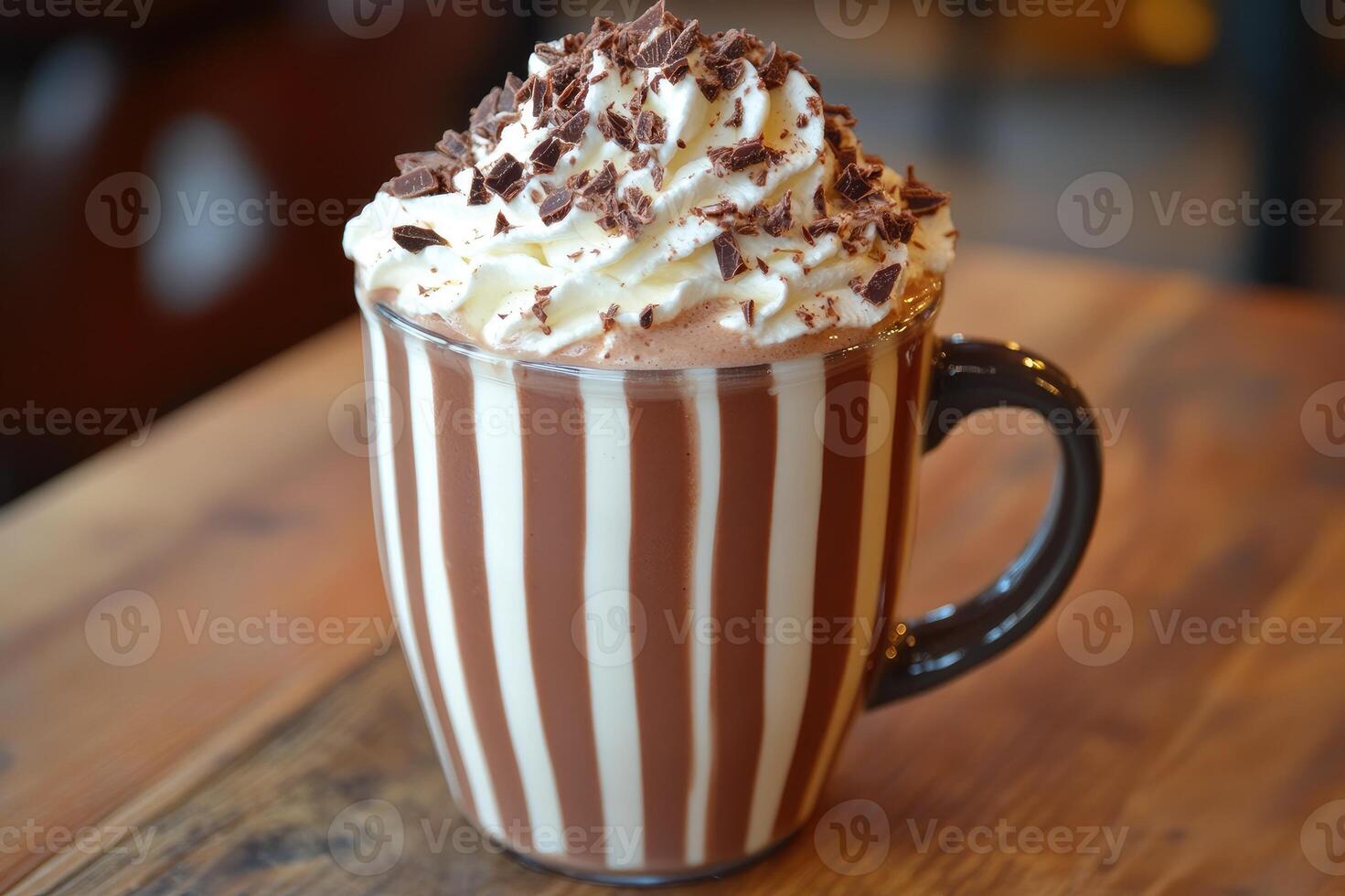 Hot chocolate with whipped cream and chocolate shavings in a striped mug photo