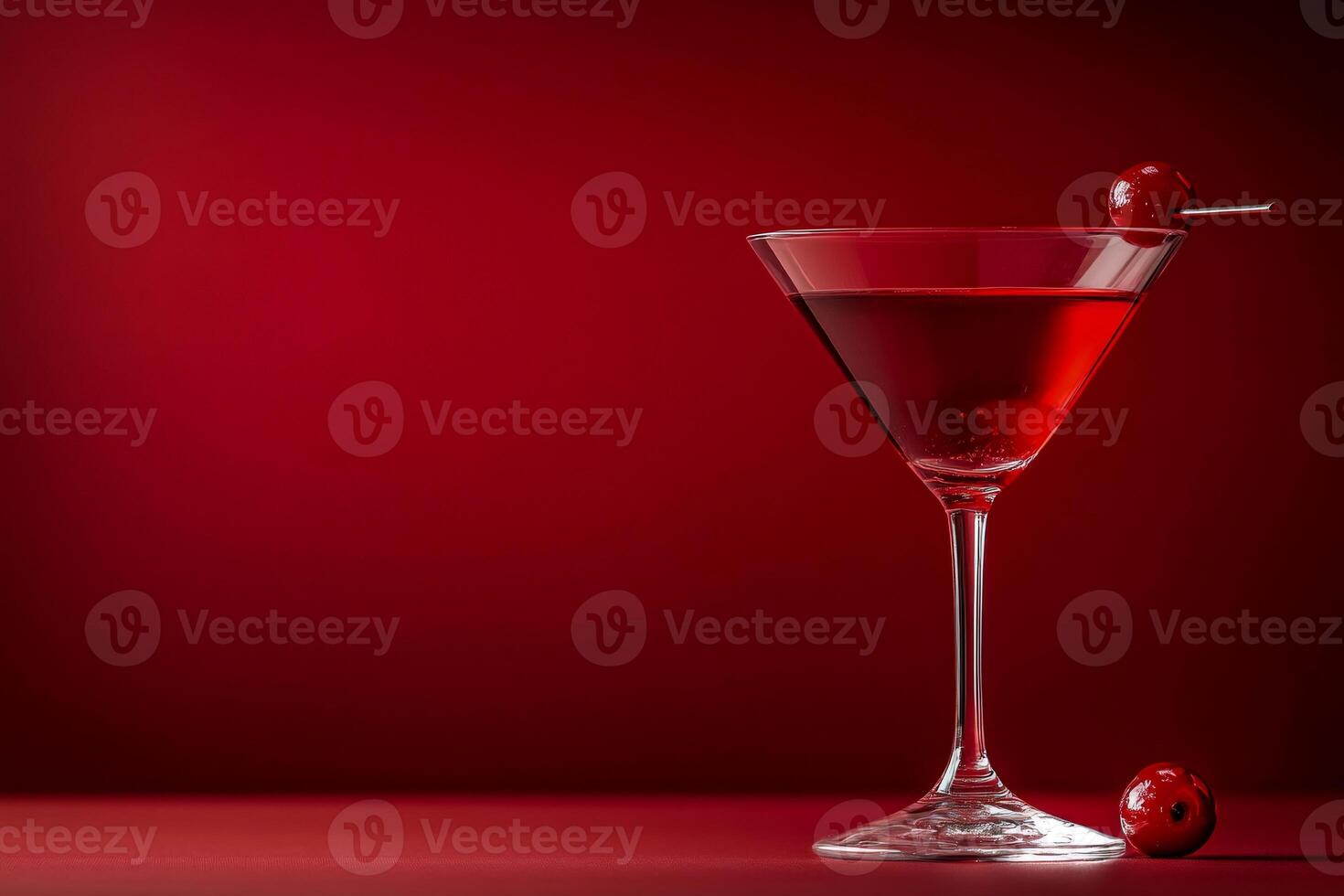 Red martini cocktail with cherry on a stick on red background photo