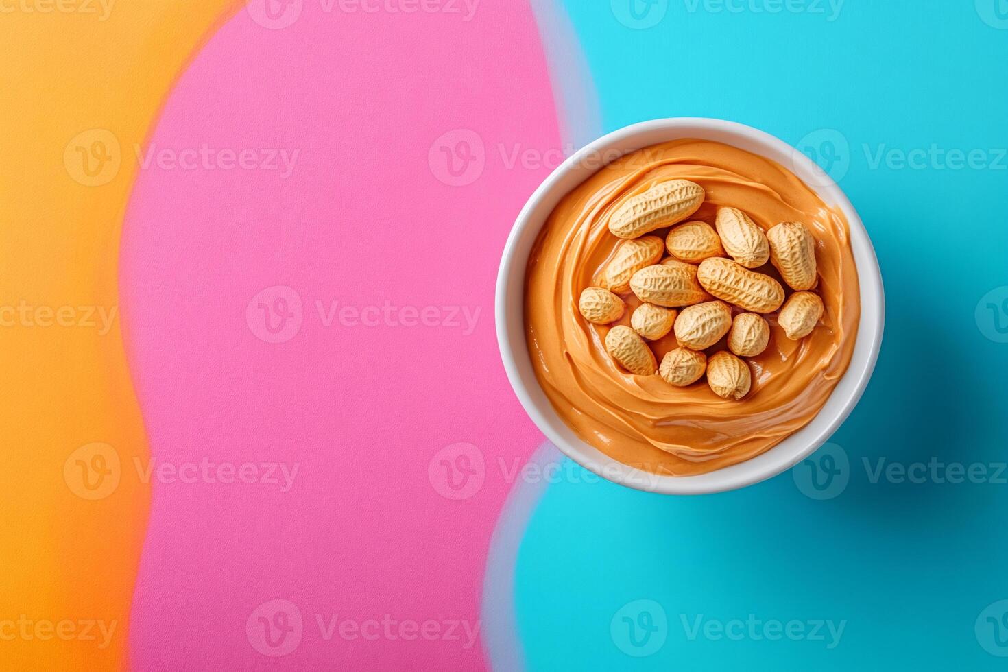 Creamy peanut butter with peanuts in a bowl on colorful background photo