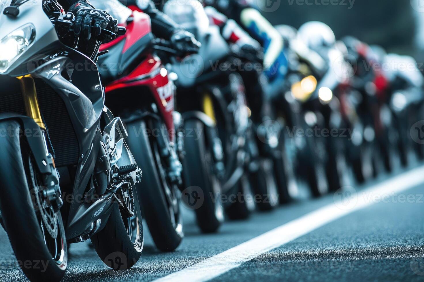 Motorcycle racers waiting at the starting line of a race track photo