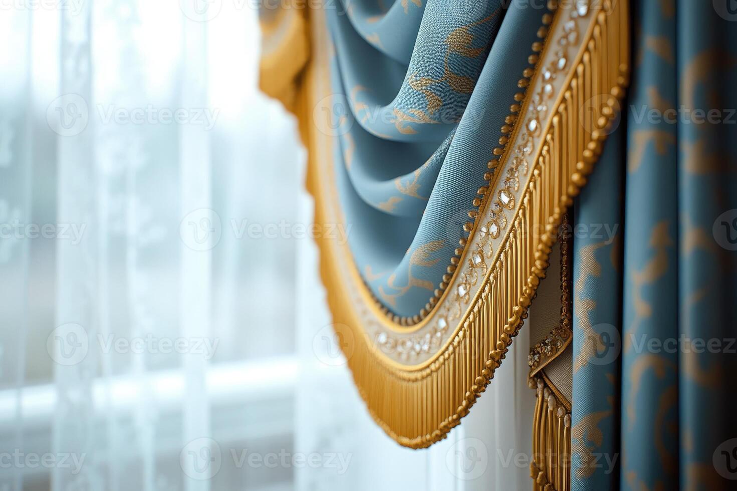 Elegant blue curtain with golden fringe hanging by the window photo