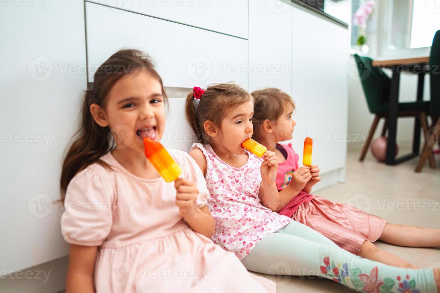Joyful children enjoying colorful ice pops on a sunny day photo