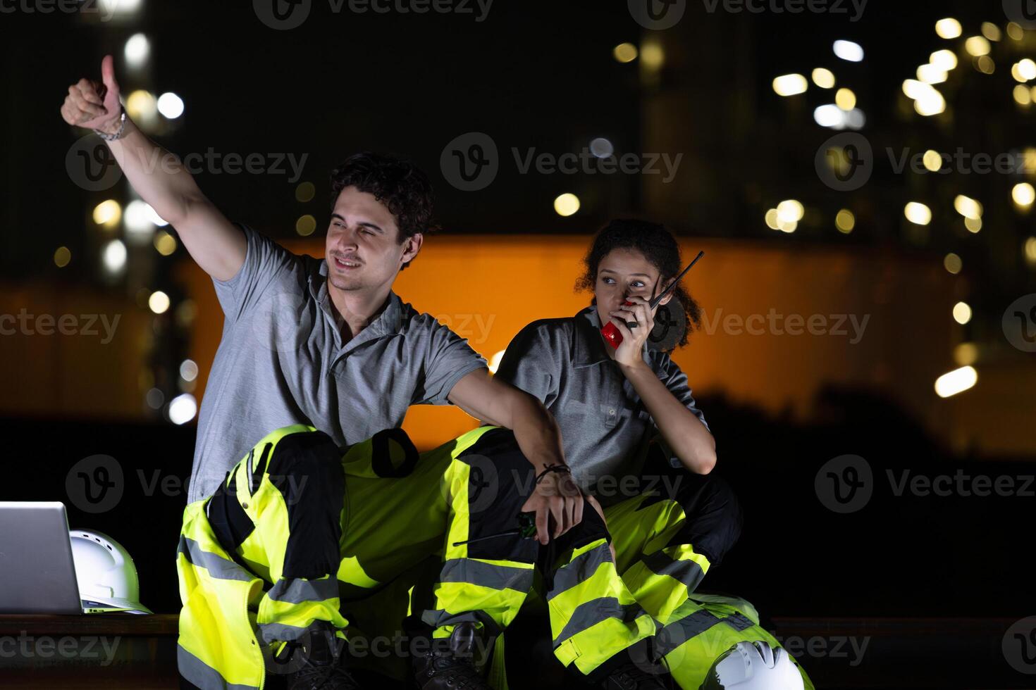 Night Shift Engineers Communicating on Site, Industrial Workers at Night Using Radio and Laptop, Happy Engineers Working Night Shift at Refinery photo