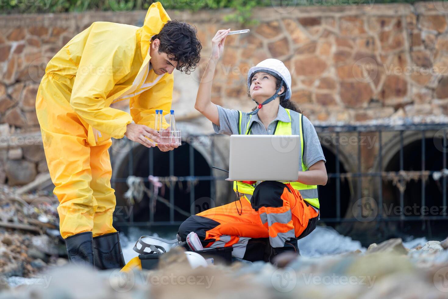 Workers Collecting Water Samples for Environmental Research, Engineers Analyzing Environmental Data on a Beach Cleanup Project, Environmental Engineers Conducting Field Work for Pollution Control photo