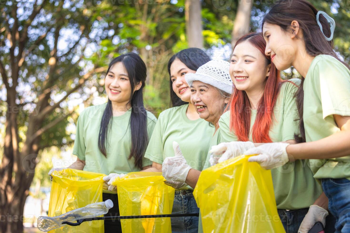 Cheerful Group of Volunteers Engaged in Cleanup Activity, Eco Volunteers Collecting Plastic Waste in Park, Teamwork for a Greener Planet, Group of Female Volunteers Picking Up Trash photo