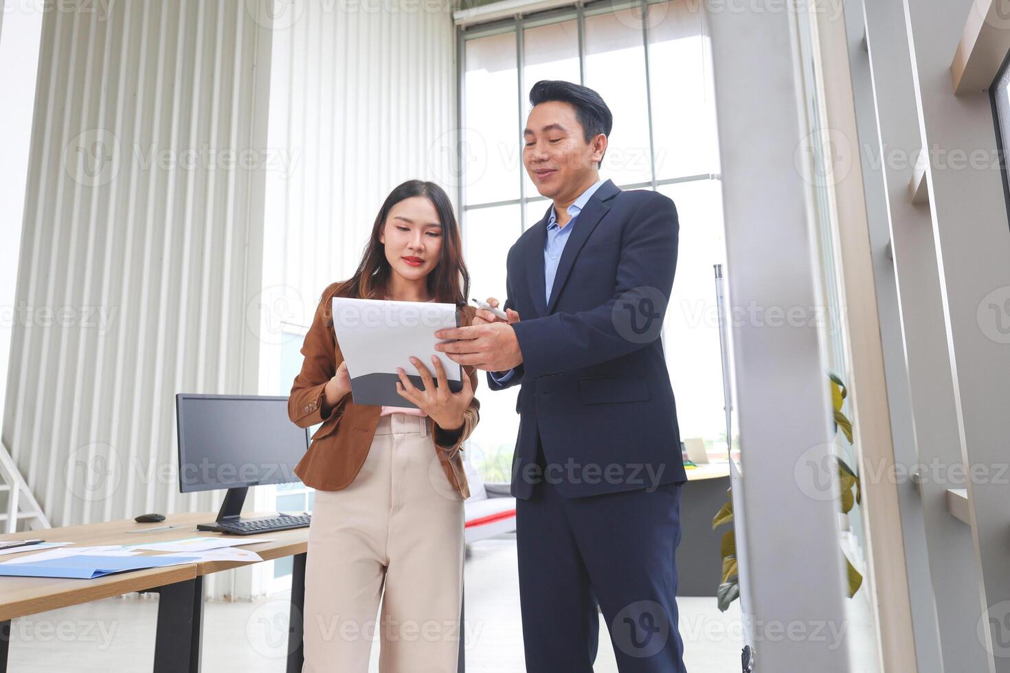 Business Colleagues Reviewing Documents in a Modern Office, Mentorship and Collaboration in a Contemporary Workspace, Professional Man and Woman Discussing Work Paperwork photo