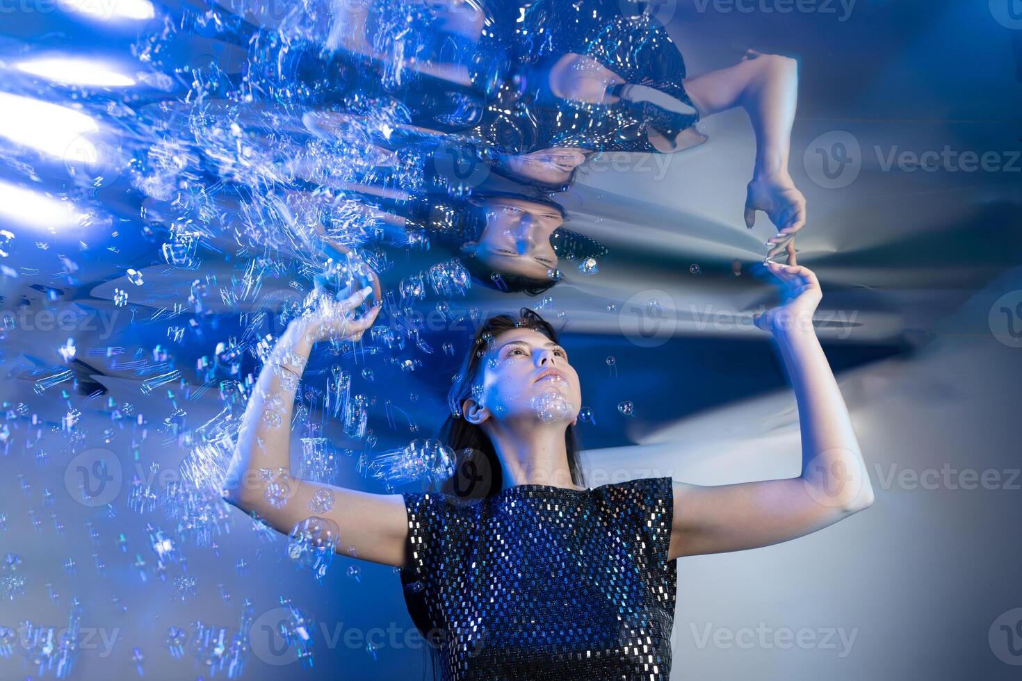 Girl in a Stunning Mermaid Outfit Submerged in Shimmering Water Creating an Enchanting Atmosphere photo