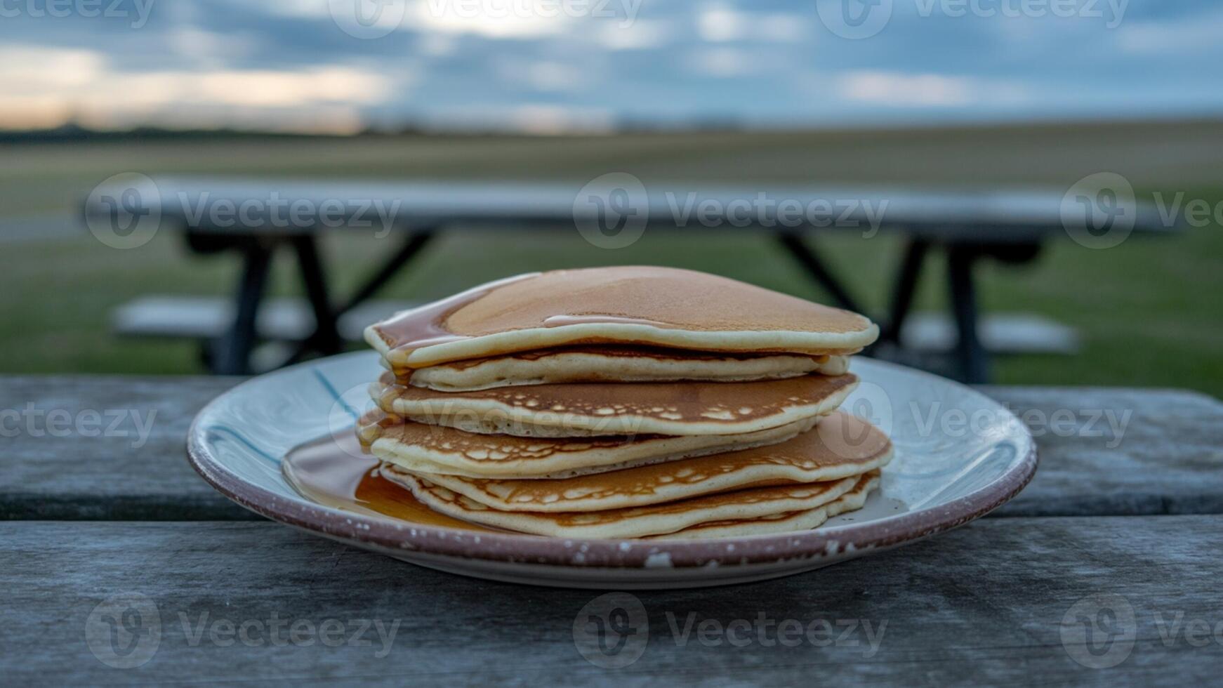 A stack of pancakes on a plate on a table photo