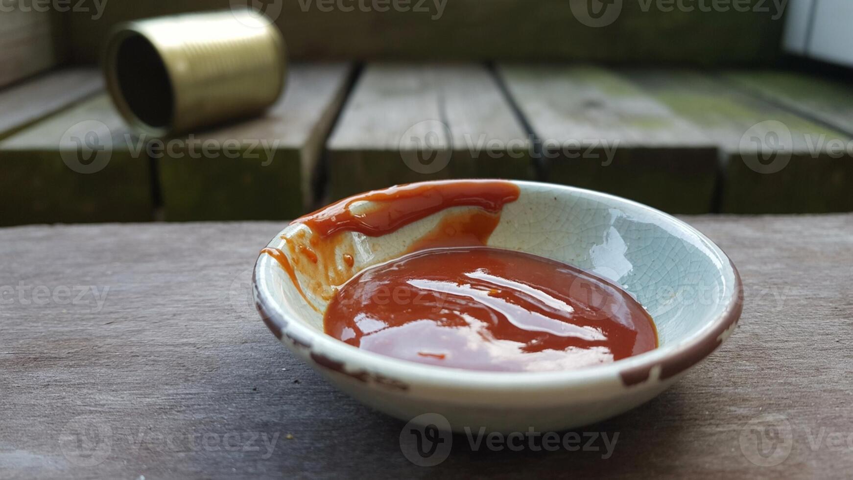 A bowl of sauce sitting on a table photo