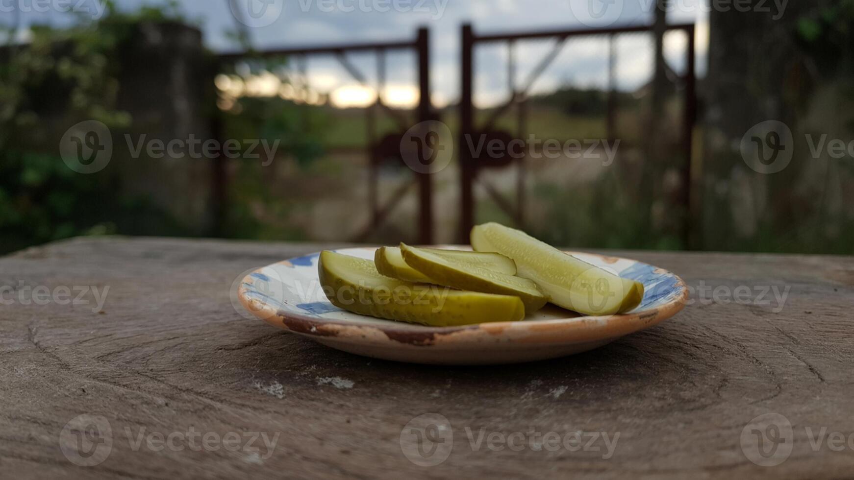 A plate with pickles sitting on top of a table photo