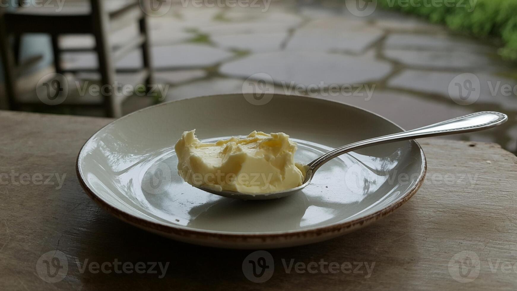 A spoon with butter in a bowl photo