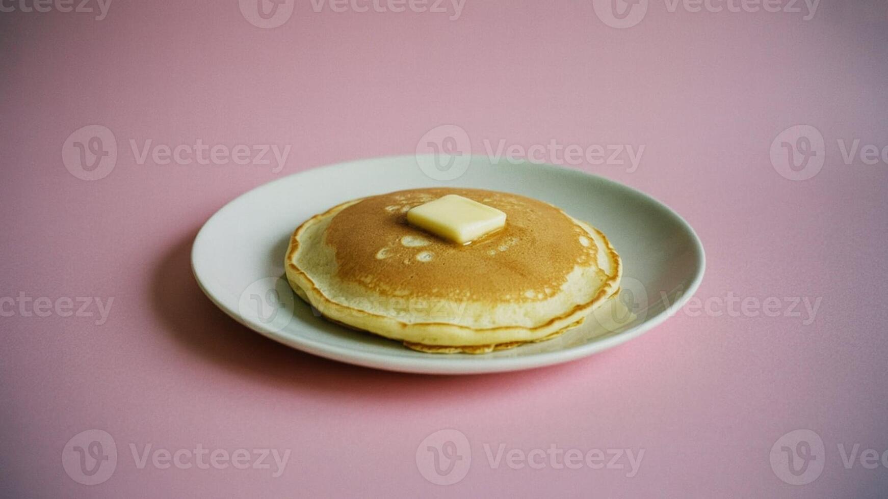 a meringue dessert on a white pla te with a gold rim sitting on a pink surfa ce in a studio setting photo
