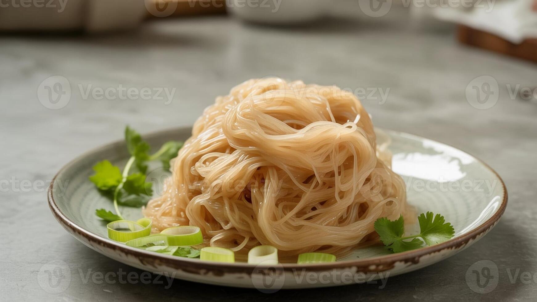 a bowl of noodles with vegeta bles a nd chopsticks resting on the rim on a wooden surfa ce nea r a wa ll photo