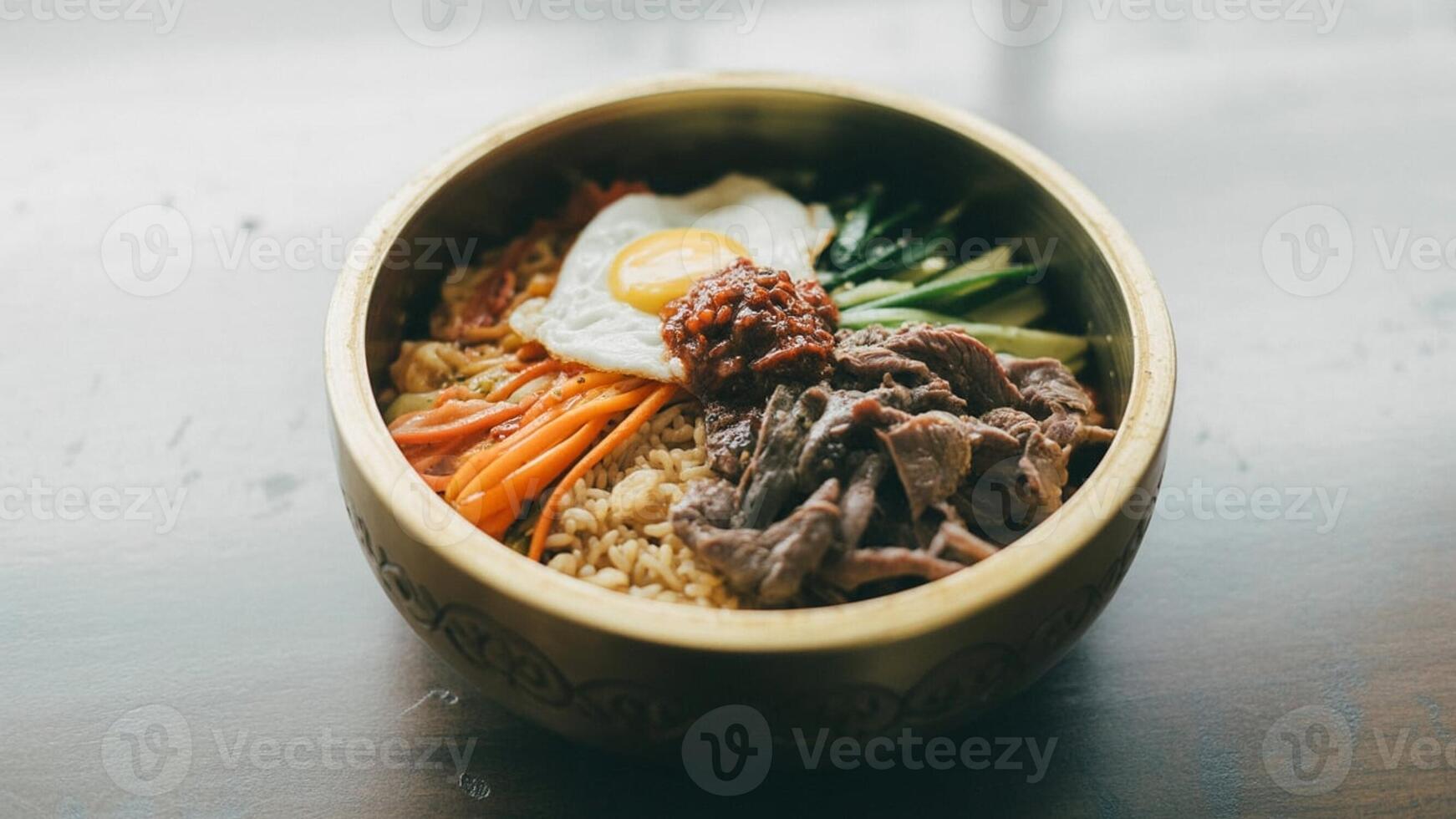 Close up of buca tini pa sta with toma to sa uce a nd ba sil in a cera mic bowl on a wooden surfa ce photo