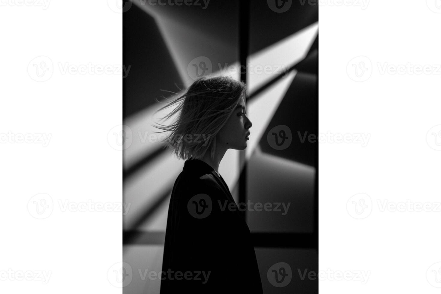 Profile view of woman with short hair in black and white against geometric pattern photo