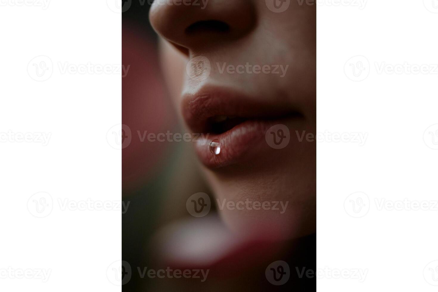 Close up of a person's face with a water droplet on their lower lip in focus view photo