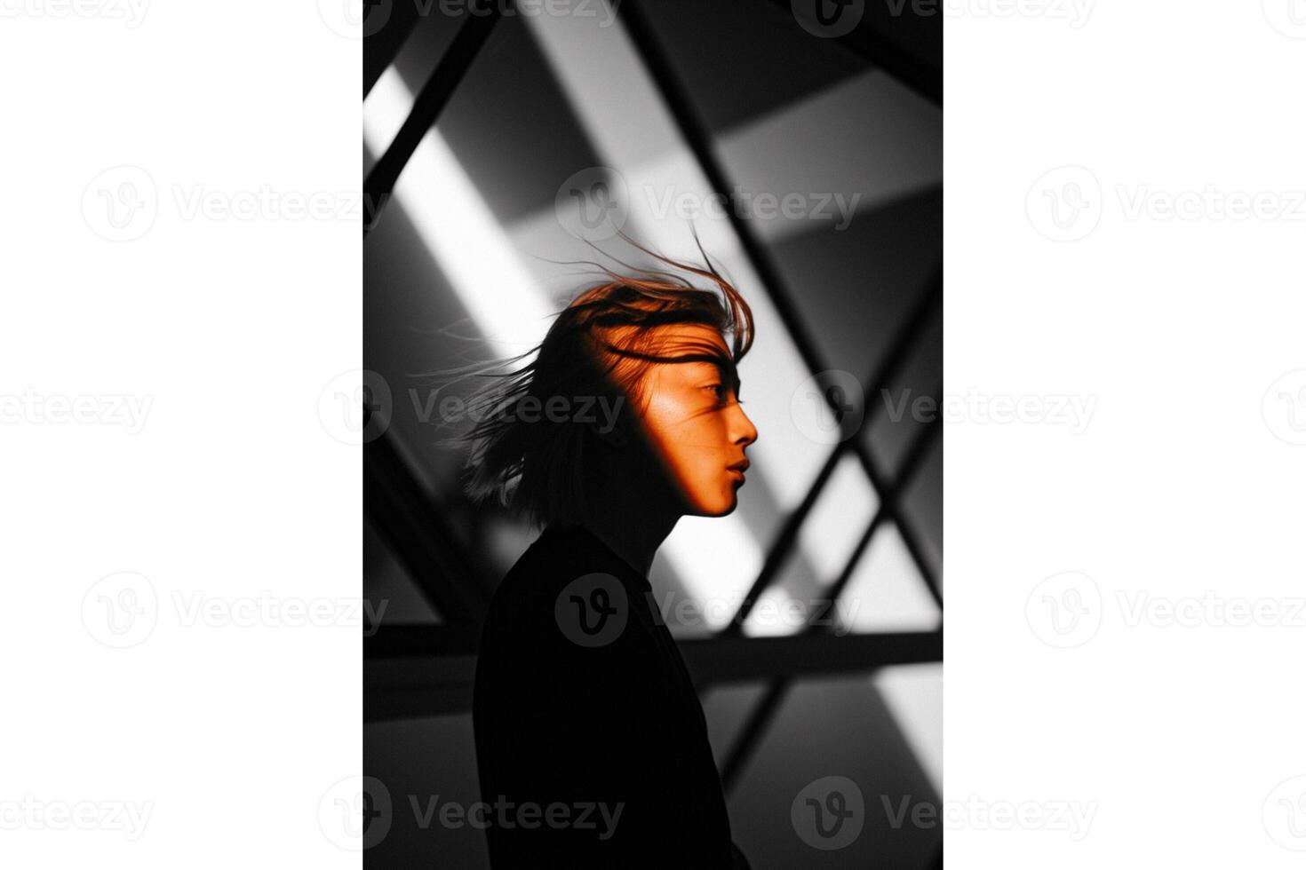 Profile of a person with windblown hair against a geometric black and white wall photo
