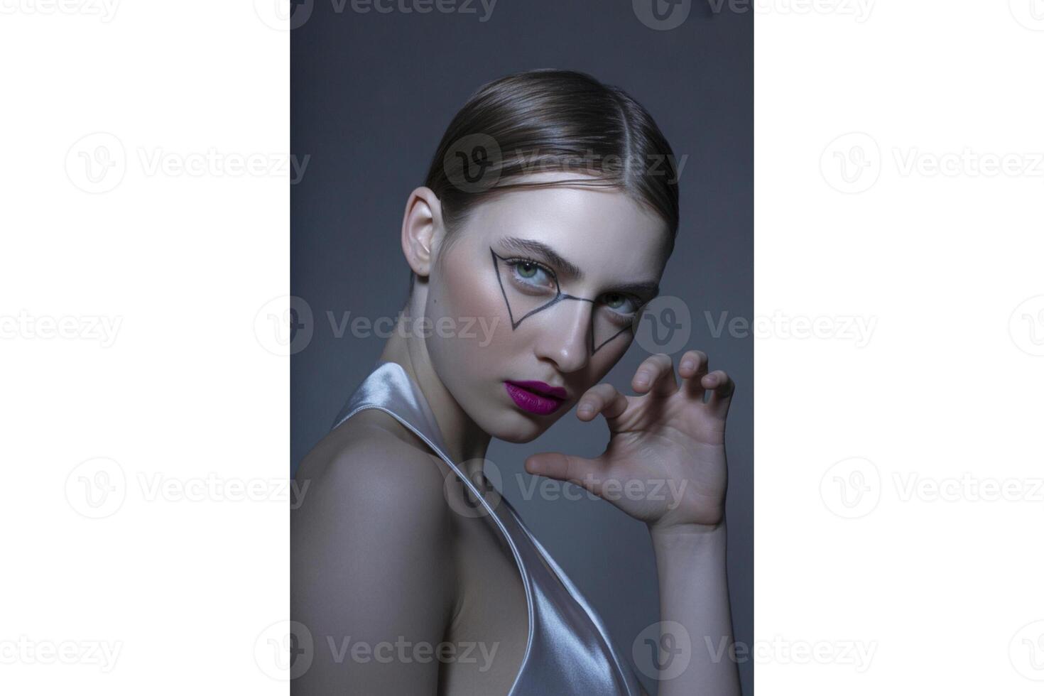 Portrait of a woman with geometric eyeliner and bright pink lipstick posing slightly photo