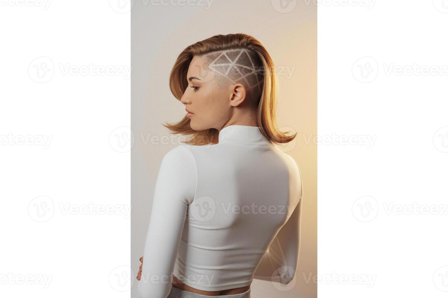 Woman with shaved geometric design hair wearing white top looking to the left photo