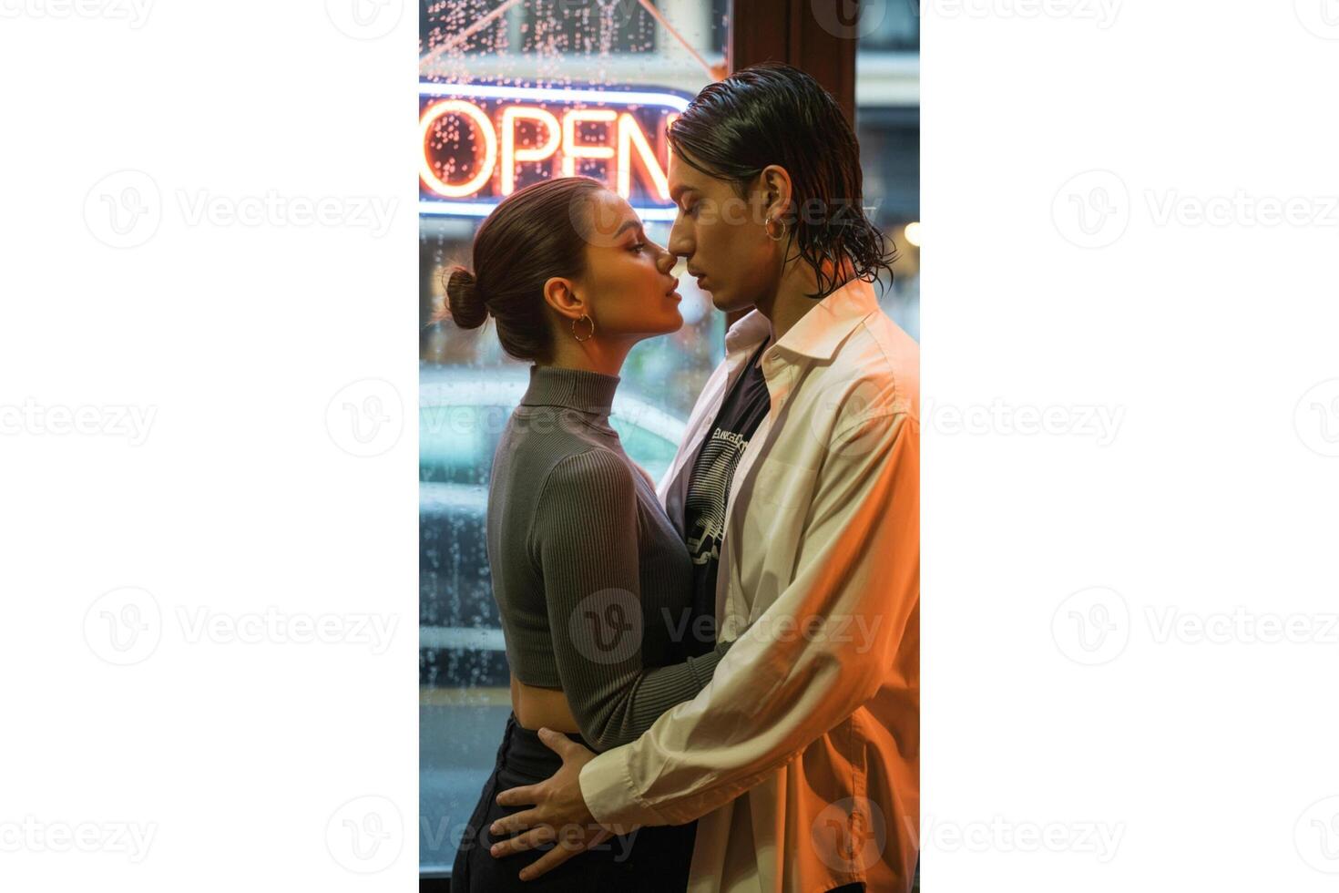 A couple embracing in front of an open neon sign at night in a city setting photo