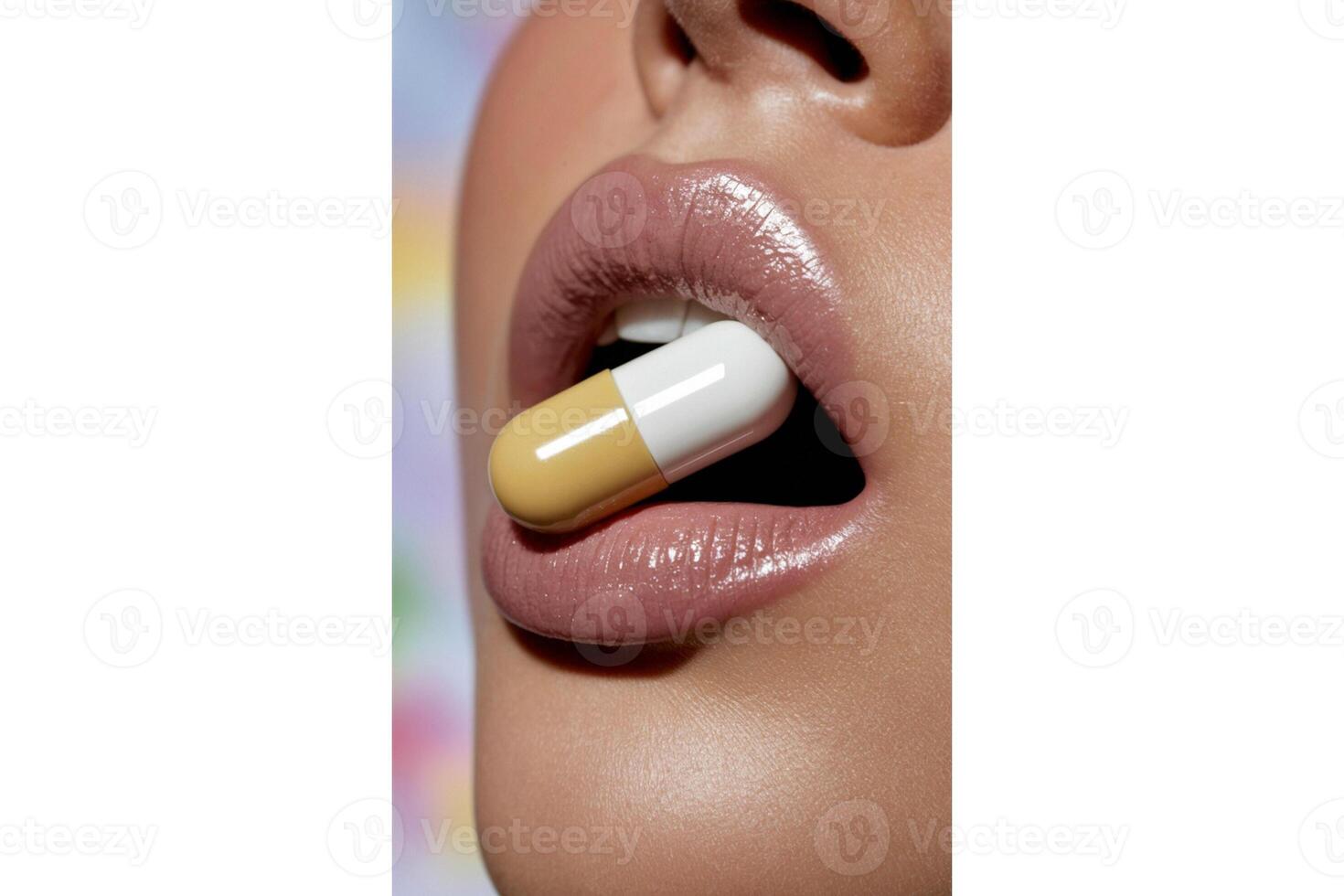 Close up of a woman's mouth holding a yellow and white capsule between her lips photo