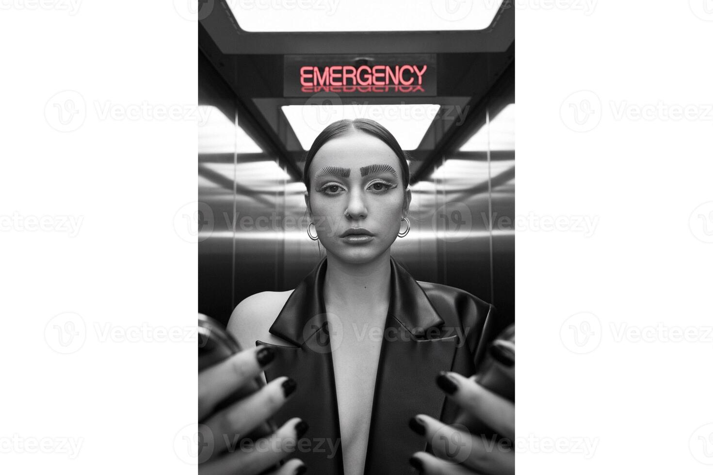 Woman with unique eyebrows in elevator under emergency sign in black and white photo