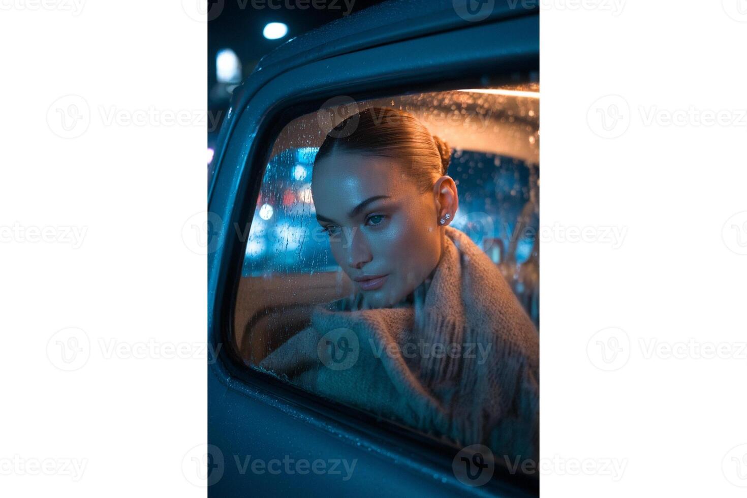 Portrait of a woman in a car on a rainy night looking out the window at the city photo