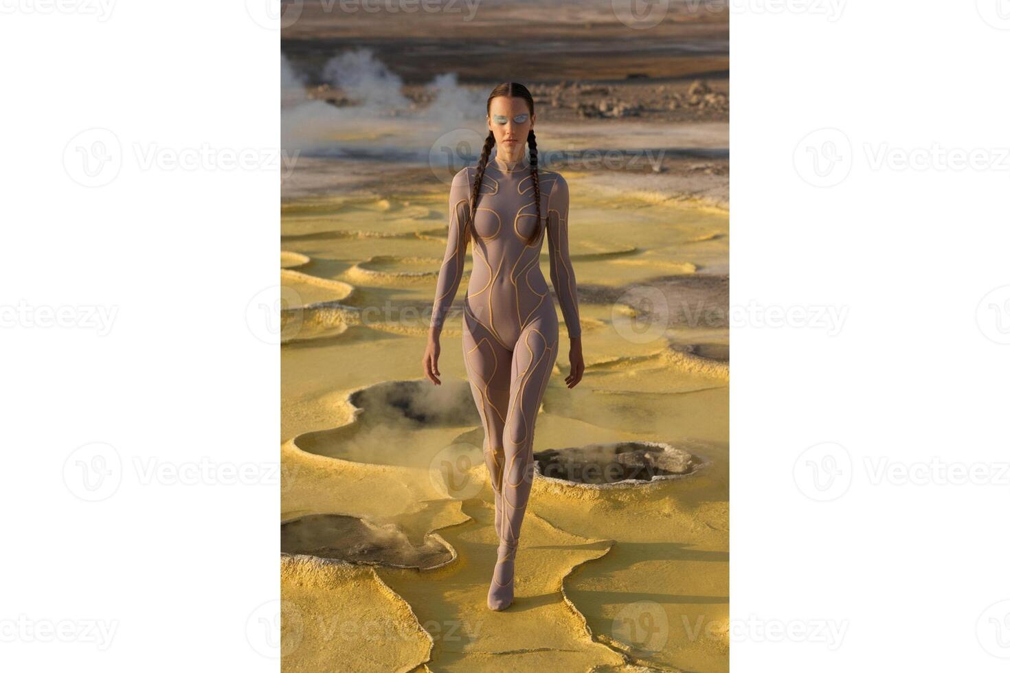 Woman in bodysuit walking on yellow terrain with steam vents in the background photo