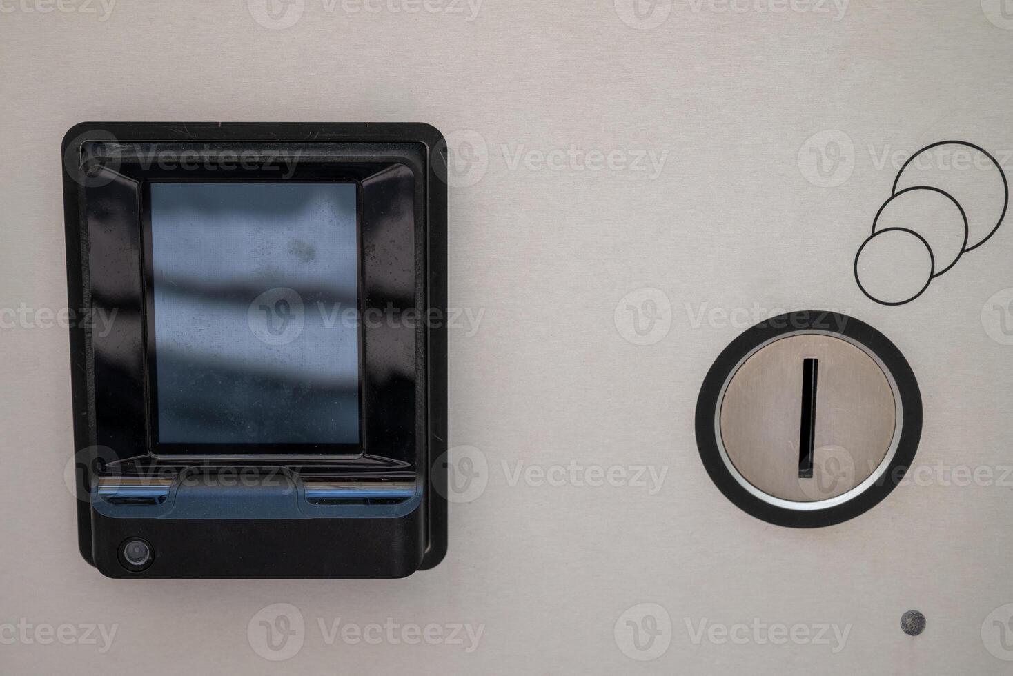 Electronic payment device on a metallic surface, featuring a rectangular black card reader with a screen. photo