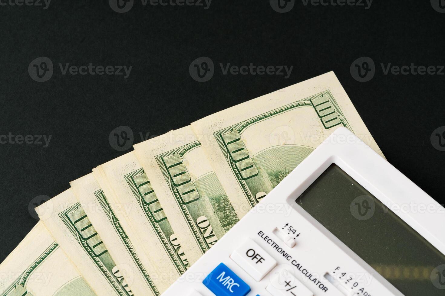 Calculator with US Dollars stack close up photo