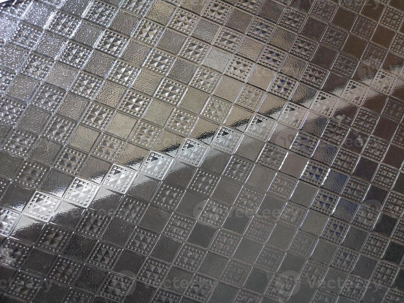 a close up of a metal tile with squares on it photo