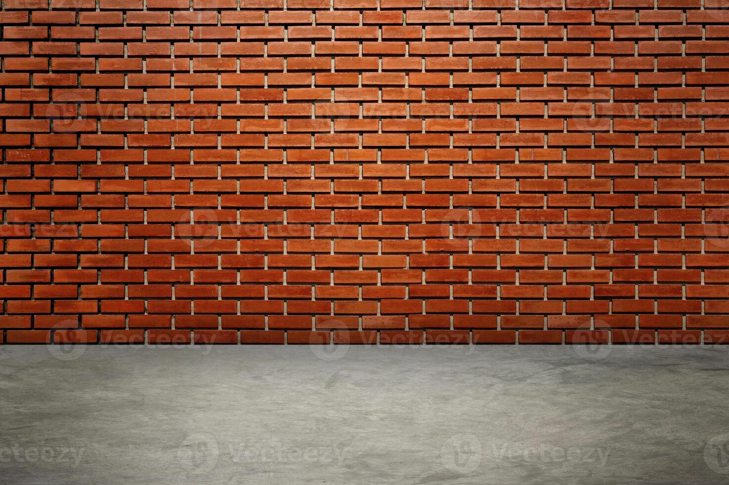 An empty room with red brick walls. The red brick walls are lit with warm lighting. photo