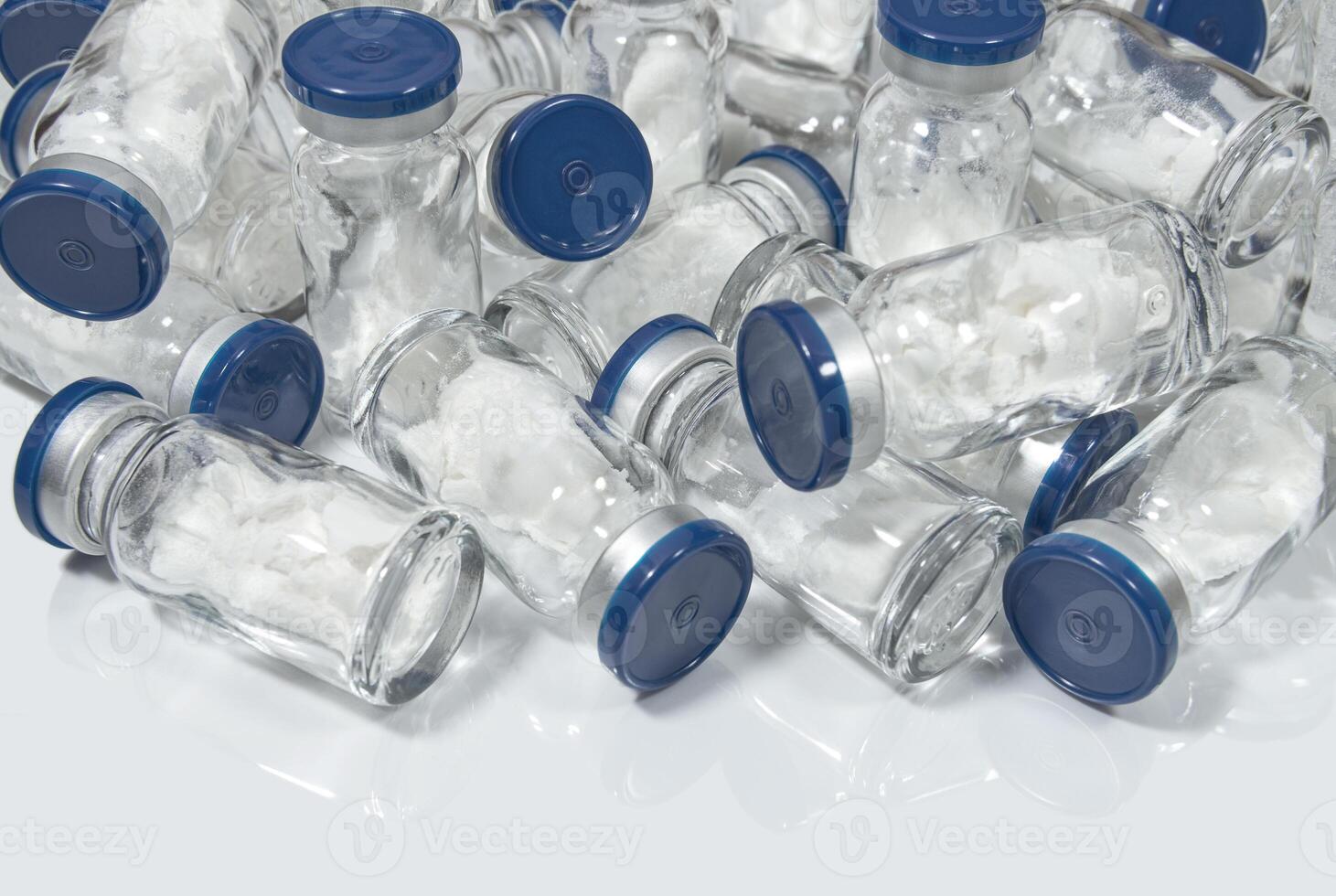Medical flasks with dry medication on a light surface photo