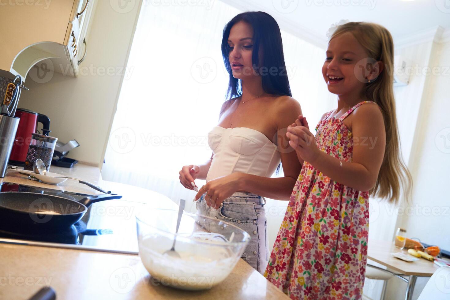 Mother and Daughter Cooking Together in a Bright Modern Kitchen During Afternoon Hours photo