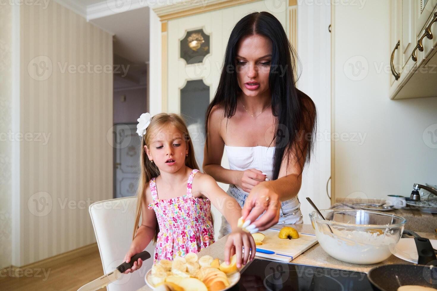 Mother and Daughter Preparing Fruit Salad Together in a Modern Kitchen During Afternoon photo