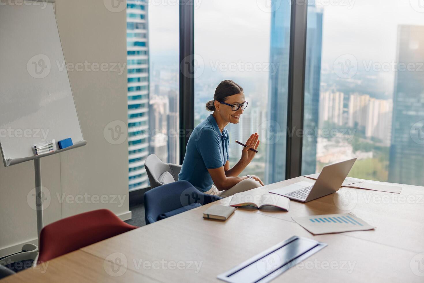 A professional woman engaging in conferencing within a modern office environment photo