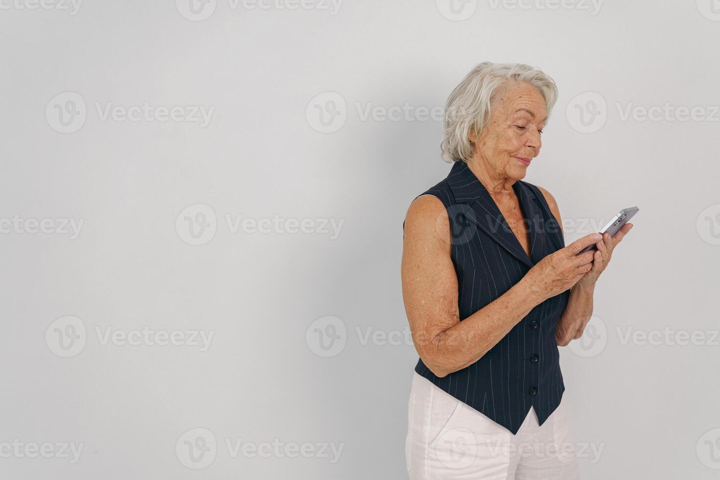 An older woman joyfully engages with her smartphone in a cozy, casual setting promoting connection photo