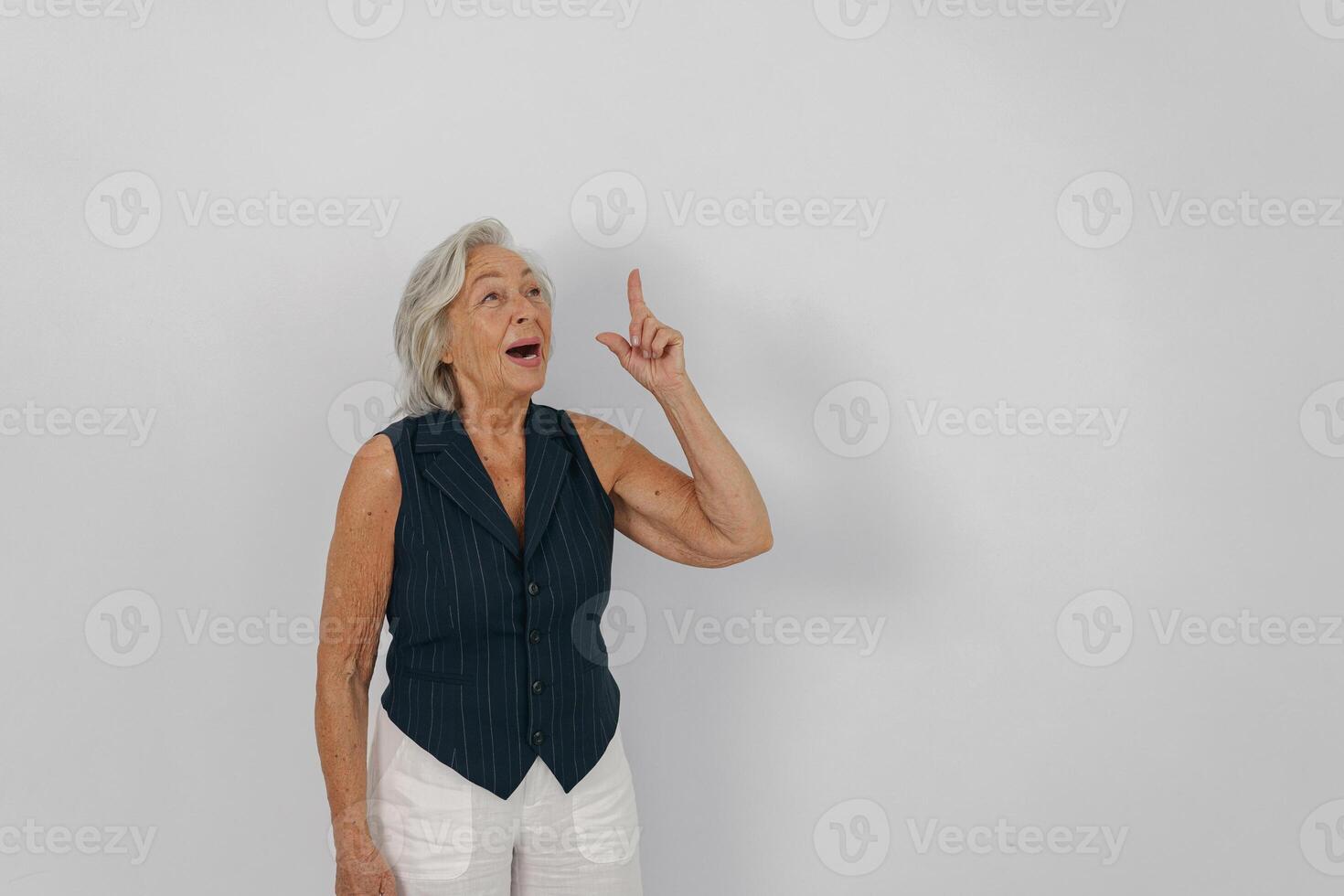 A Senior Woman is Gesturing with Enthusiasm and Joy in a Bright Studio Environment photo