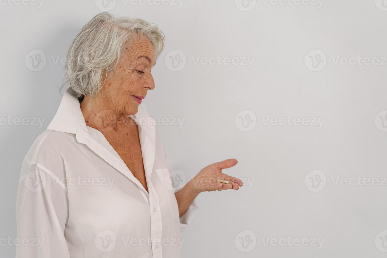 This elegant senior woman is gracefully gesturing in a beautifully soft lighting atmosphere photo