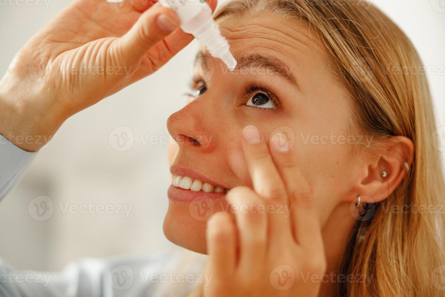 A woman is applying eye drops to achieve relief and hydration for her eyes comfort photo