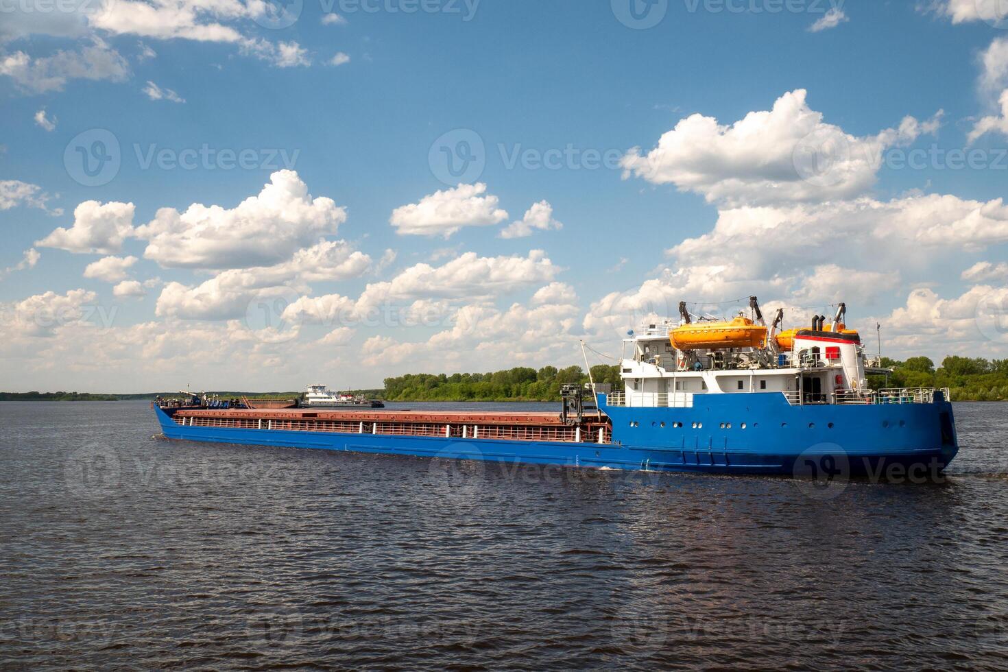 A cargo ship, a cargo ship or an oil tanker, is moving along the river. Logistics and cargo transportation by ship, Freight transportation, river navigation photo