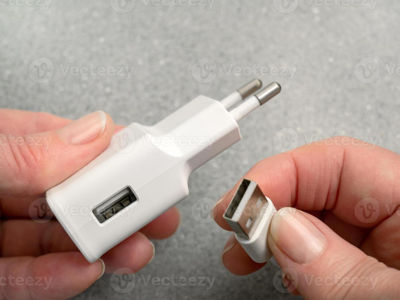 The woman's hands connect or disconnect the USB cable and AC power adapter. AC power charger with USB connectors. AC charger, adapter with USB input photo