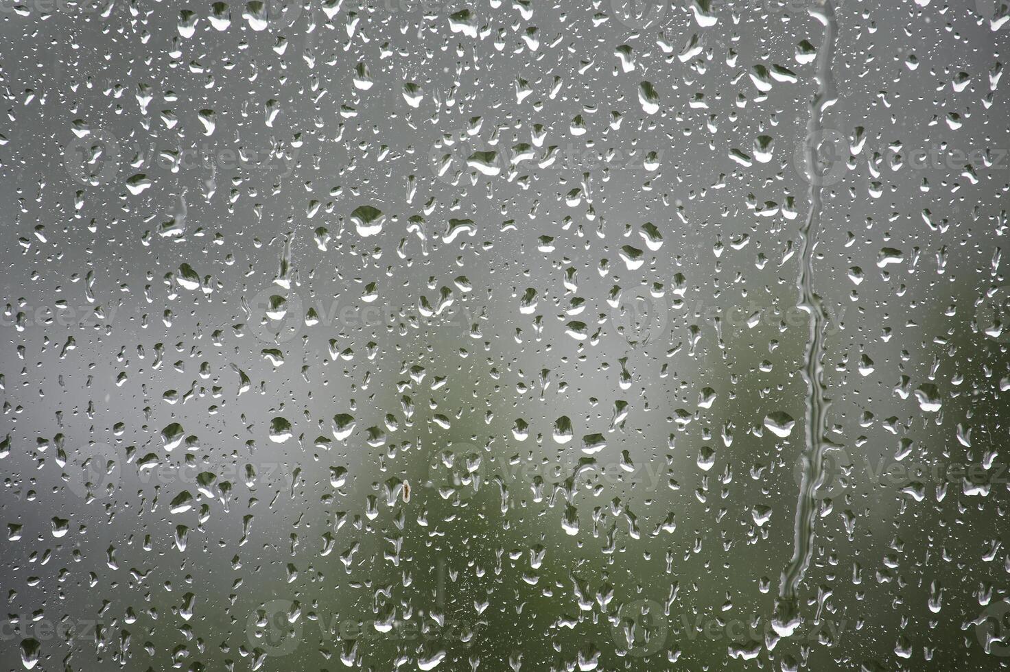 Raindrops on a window create a beautiful, abstract scene with a blurred background. photo